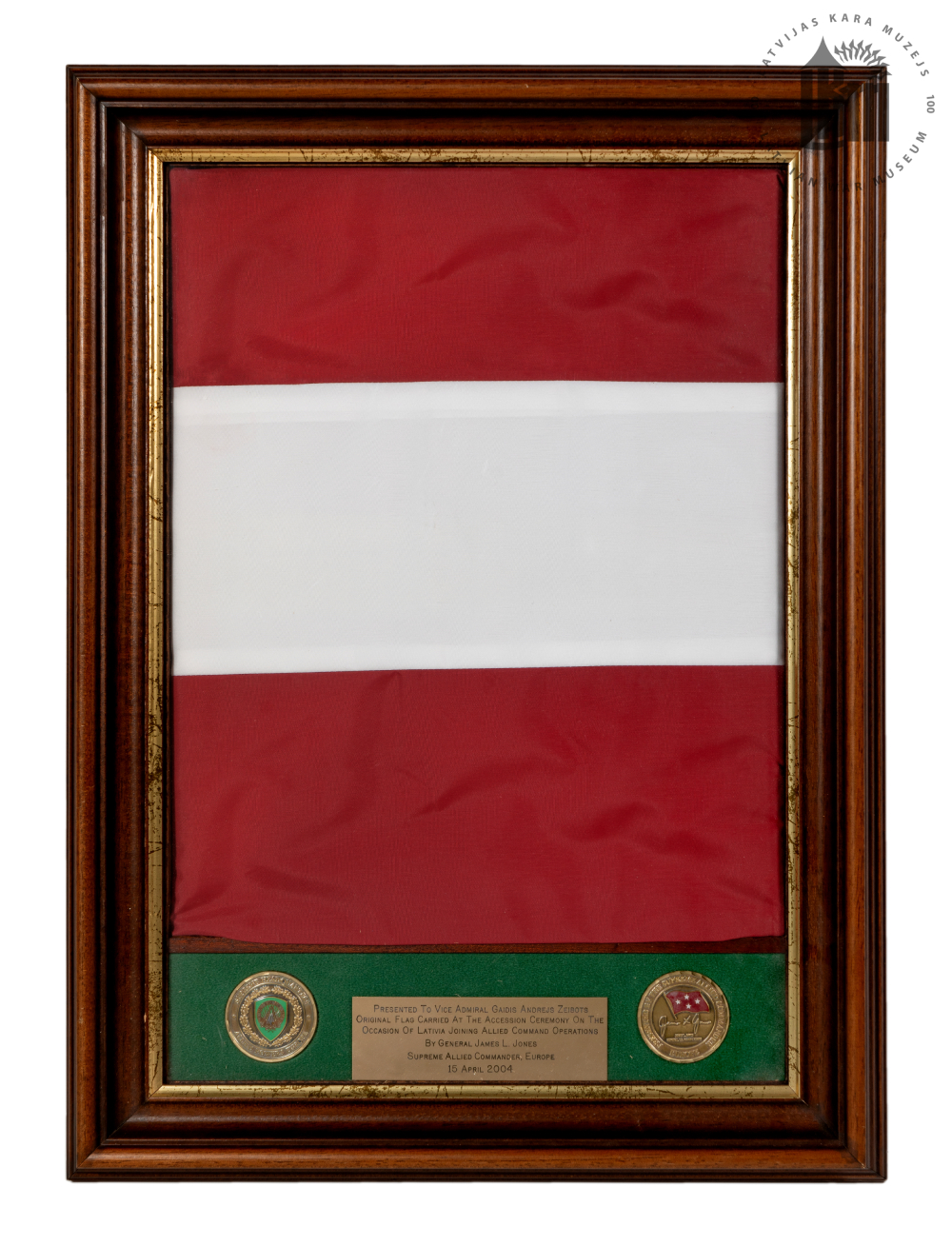 Plakete ar Latvijas Valsts karogu un NATO Apvienoto spēku Eiropā komandiera ģenerāļa Dž. Džonsa dāvinājuma tekstu. Beļģija, Monsa, 2004. gada aprīlis. LKM krājums