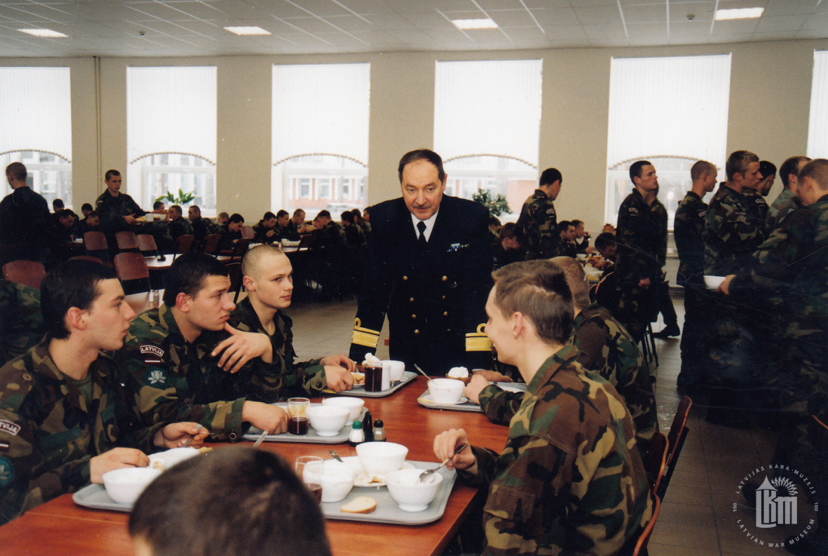 NBS komandieris G. A. Zeibots sarunā ar karavīriem jaunajā ēdnīcā. Ādaži, 2003./2004. gada ziema. Fotogrāfs nav zināms. LKM krājums